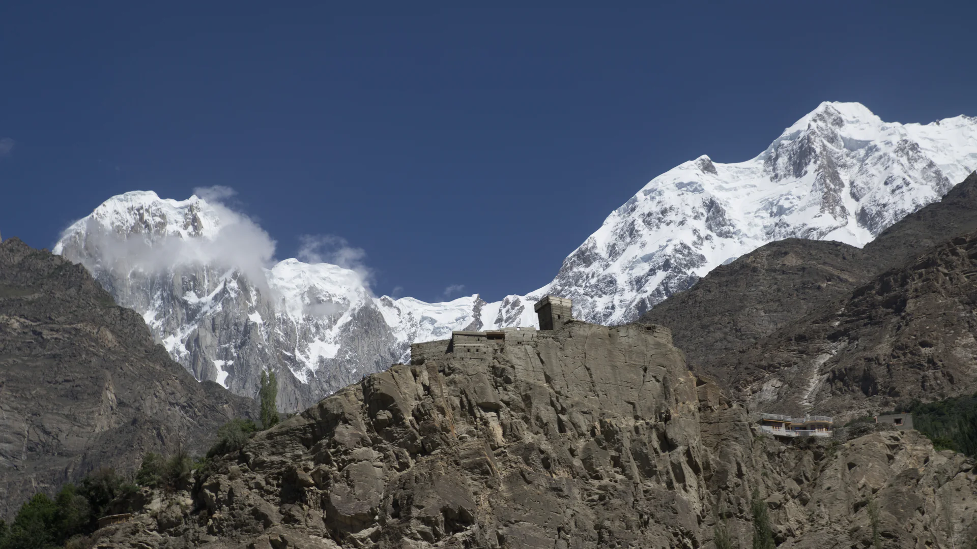 Historic Altit Fort standing below the snow-covered Hunza Peak in Pakistan